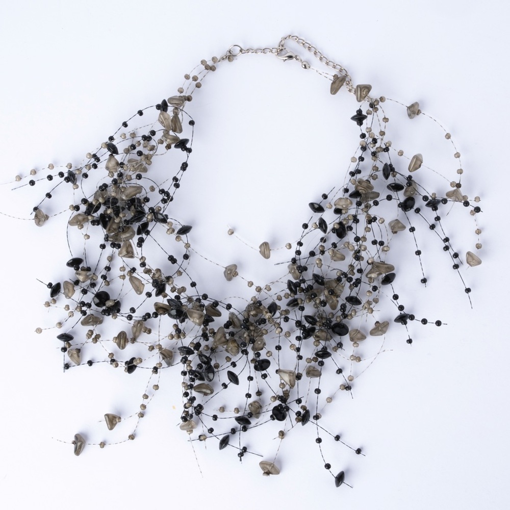 is a multi-strand beaded statement necklace featuring black and‎ grey B4